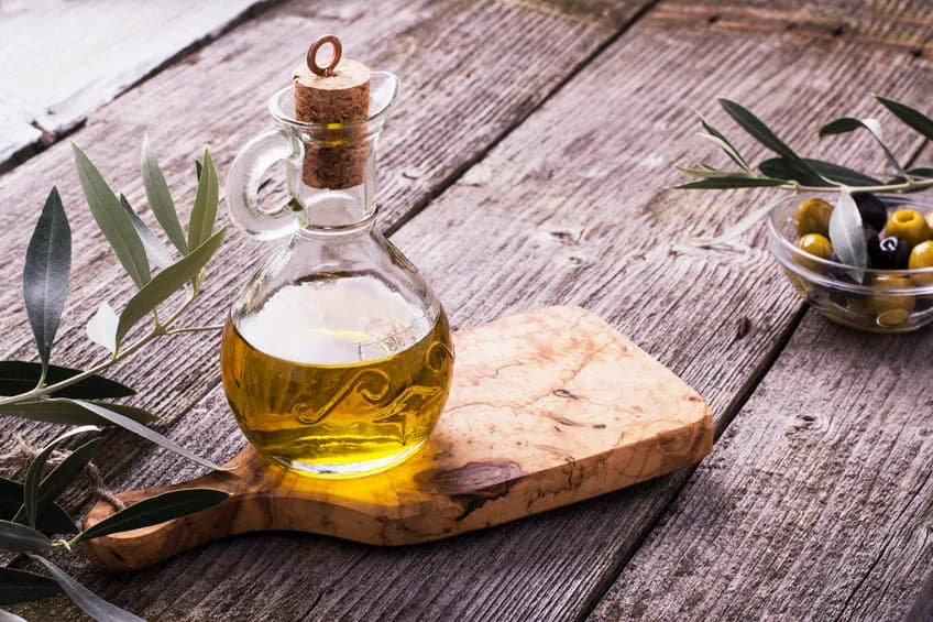 Olive oil bottle on wooden board